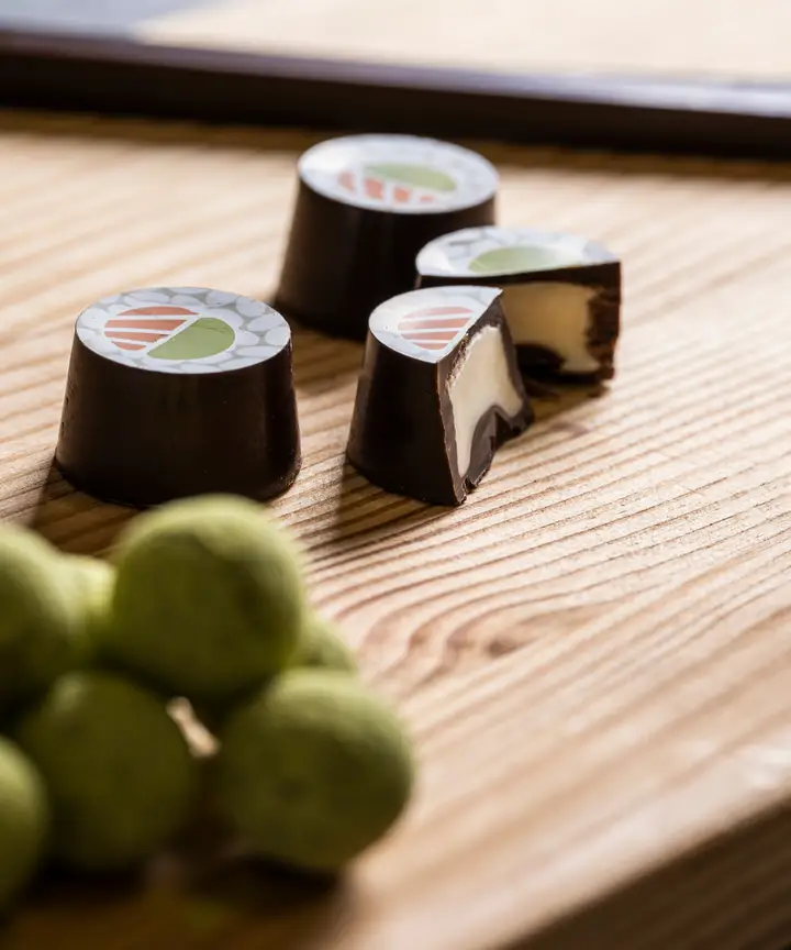 Ciocosushi: cioccolatini a forma di sushi su un tagliere di legno, con le palline verdi al tè matcha